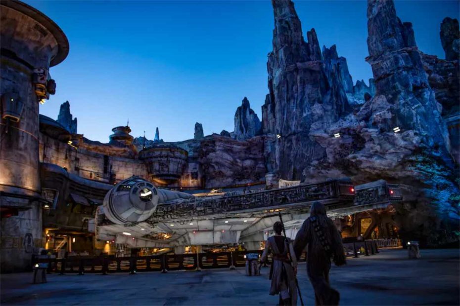 Rey and Chewbacca walking through Star Wars: Galaxy’s Edge at dusk